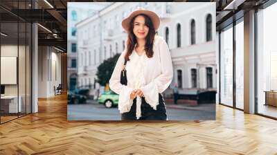 Portrait of young beautiful smiling hipster woman in trendy summer white blouse and jeans. Carefree woman posing in the street in sunny day. Positive model outdoors. Cheerful and happy, closeup Wall mural