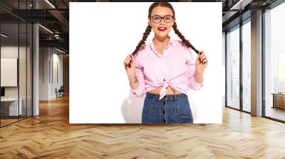 Portrait of young happy smiling woman model with bright makeup and red lips with two horns in summer colorful pink tied shirt drinking soda from glass bottle with straw, isolated on white Wall mural