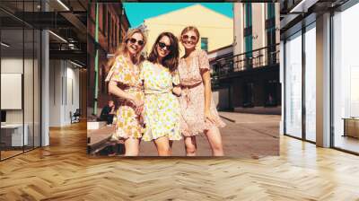 Three young beautiful smiling hipster female in trendy summer dresses  clothes. Sexy carefree women posing in the street. Positive models having fun, talking, chatting. Going crazy. In sunglasses Wall mural