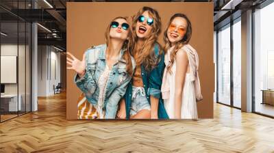 Three young beautiful smiling hipster girls in trendy summer casual clothes. Sexy carefree women posing on golden background. Positive models going crazy Wall mural