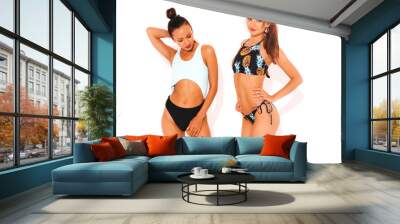 Two beautiful sexy smiling hipster women in swimming  lingerie. Trendy hot models having fun in studio. Girls isolated on white Wall mural