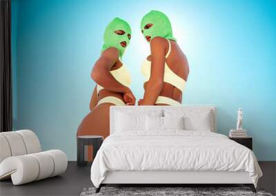 Two beautiful sexy women in green underwear. Models wearing bandit balaclava mask. Hot seductive female in nice lingerie posing in the street at sunny day, blue sky. Crime and violence. Perfect body Wall mural