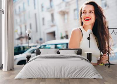 Young beautiful smiling brunette woman in trendy summer clothes. Sexy carefree female posing in the street in sunny day. Positive model outdoors. Cheerful and happy, red lips. Glamorous portrait Wall mural