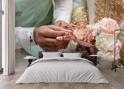 The groom puts a diamond ring on the bride's finger during an Indian wedding ceremony. Henna drawings in the form of Indian traditional patterns on the hands of the bride. Traditional Indian patterns Wall mural