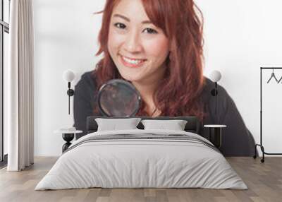 asian office girl hold magnifying glass in front of her and smil Wall mural