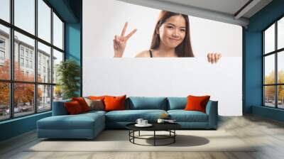 Young Asian woman show victory sign with blank sign. Wall mural