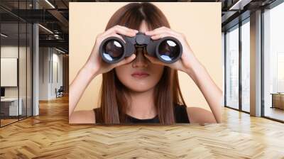 Young Asian woman with binoculars. Wall mural