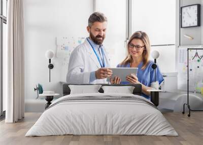 A dentist with dental assistant in modern dental surgery, working. Wall mural