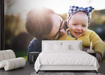 A father with his toddler daughter outside in spring nature. Wall mural