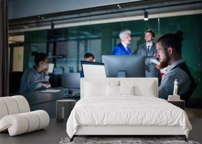 A group of business people in an office at night, using computer. Wall mural