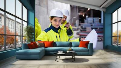 A group of engineers standing on construction site, working. Wall mural