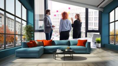 A group of young business people in an office, brainstorming. Wall mural