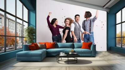 A group of young people standing in a studio, enjoying a party. Wall mural