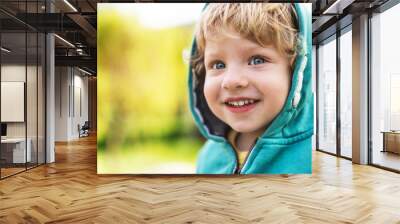 A happy toddler boy outside in spring nature. Close up. Wall mural