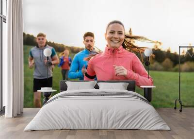 A large group of people cross country running in nature. Wall mural