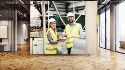 A portrait of an industrial man and woman engineer with tablet in a factory. Wall mural