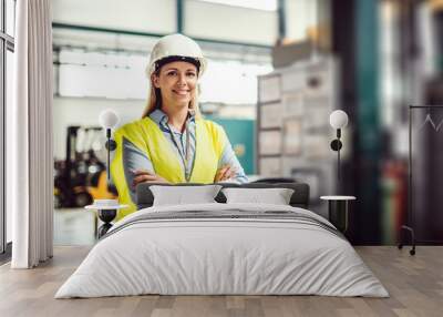 a portrait of an industrial woman engineer standing in a factory, arms crossed. Wall mural