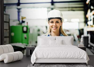 A portrait of an industrial woman engineer standing in a factory. Wall mural