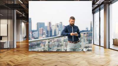 A portrait of businessman with smartphone standing against London view panorama. Wall mural