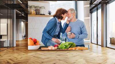 A portrait of senior couple in love indoors at home, laughing. Wall mural