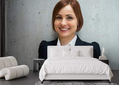 A portrait of young businesswoman standing in office, looking at camera. Wall mural