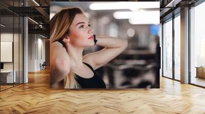 A portrait of young girl or woman standing in a gym. Copy space. Wall mural