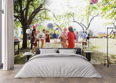 A senior couple dancing on a garden party outside in the backyard. Wall mural