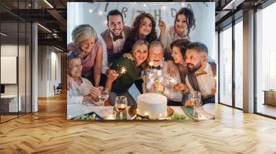 A senior man with multigeneration family celebrating birthday on indoor party. Wall mural