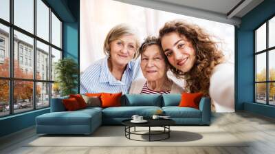 A teenage girl with mother and grandmother at home. Wall mural