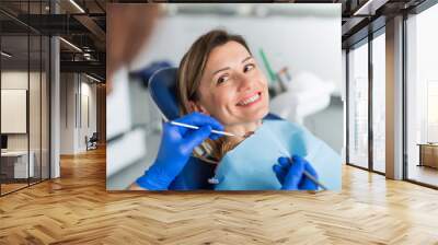 A woman has a dental check-up in dentist surgery. Wall mural