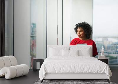 A woman with tablet standing by the window against London panorama. Wall mural