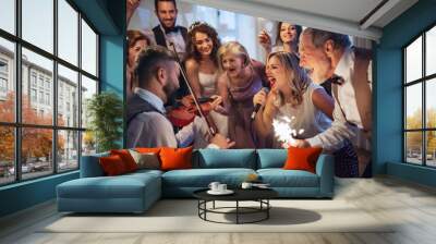 A young bride, groom and other guests dancing and singing on a wedding reception. Wall mural