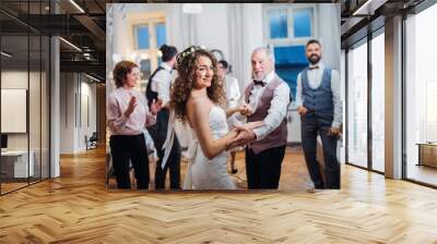 A young bride dancing with grandfather and other guests on a wedding reception. Wall mural