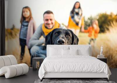 A young family with two small children and a dog on a meadow in autumn nature. Wall mural