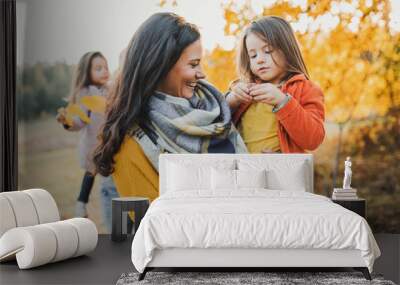 A young family with two small children in autumn nature. Wall mural