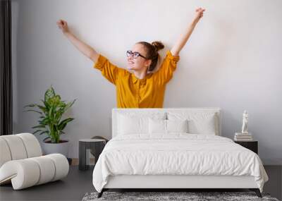 A young female student sitting on floor using laptop when studying. Wall mural