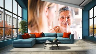 An elderly grandmother with an adult granddaughter at home. Wall mural