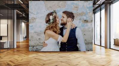 Beautiful bride and groom in front of old shabby house. Wall mural