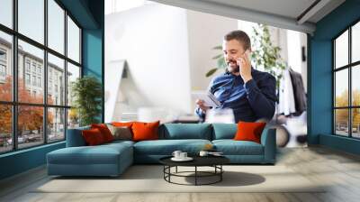 Businessman in wheelchair with smartphone in his office. Wall mural