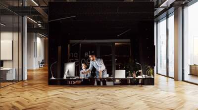 Businesspeople in the office at night working late. Wall mural