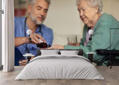 Caregiver doing regular check-up of senior woman in her home. Wall mural