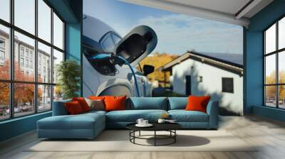 Charging an electric car in home,sustainable transportation concept. Wall mural