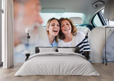 Cheerful adults sitting in car, going on a trip. Wall mural