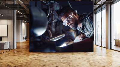 Close up of young concentrated african american industrial man working on cutter indoors in metal workshop. Wall mural