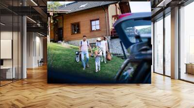 Family with two small children going on cycling trip in countryside. Wall mural