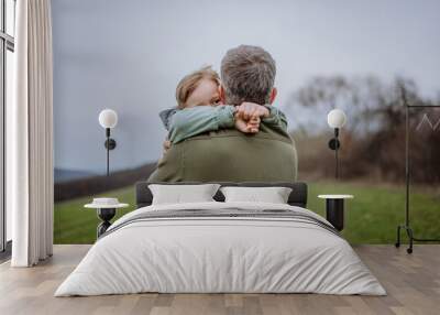 Father and his little son on a walk in nature. Wall mural