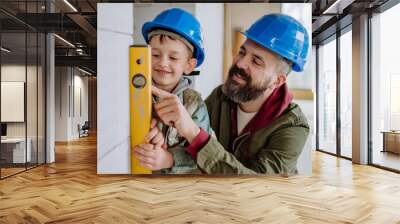 Father and his little son working on their unfinished house. Wall mural