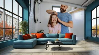 Father brushing his little daughter's hair in bathroom, morning routine concept. Wall mural