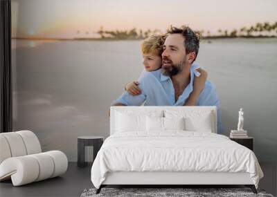 Father with his son enjoying together time at sea. Wall mural