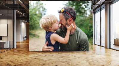 Father with small son hiking outdoors in summer nature, having fun. Wall mural